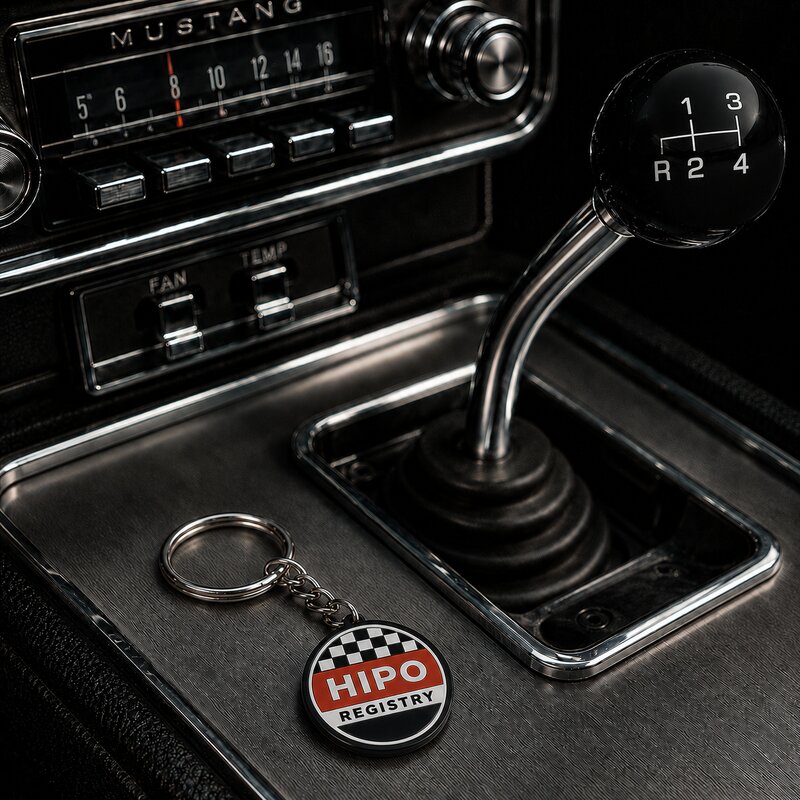 HiPo Registry keychain on the center console of a 1965 Mustang next to the shifter and dashboard radio